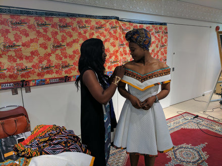 Model being fitted for our Ambazinia off-shoulder dress